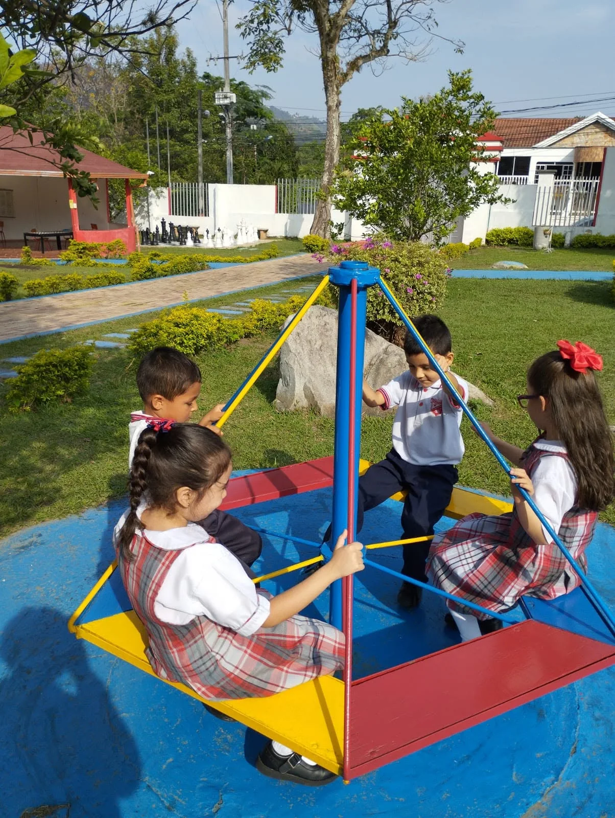 Pequeños estudiantes juegan en una zona verde del colegio.