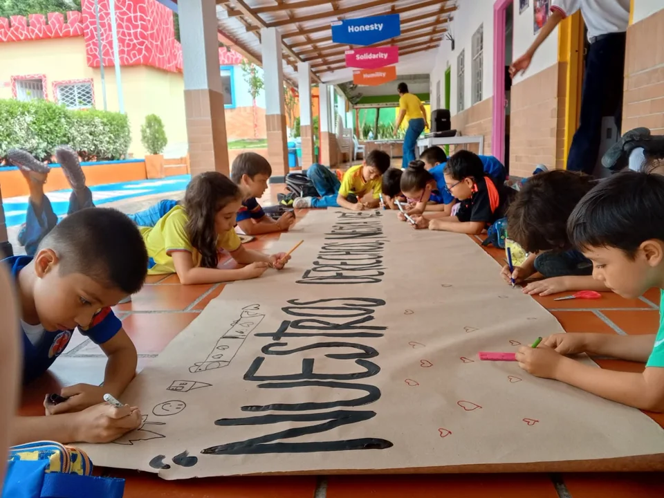 Estudiantes trabajando en un mural sobre sus derechos